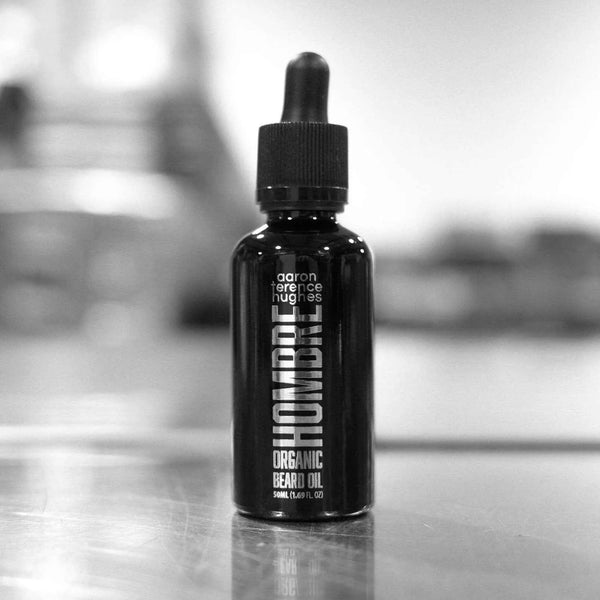 Huile bio pour barbe pour homme d'Aaron Terence Hughes, flacon avec compte-gouttes et étiquette visible.