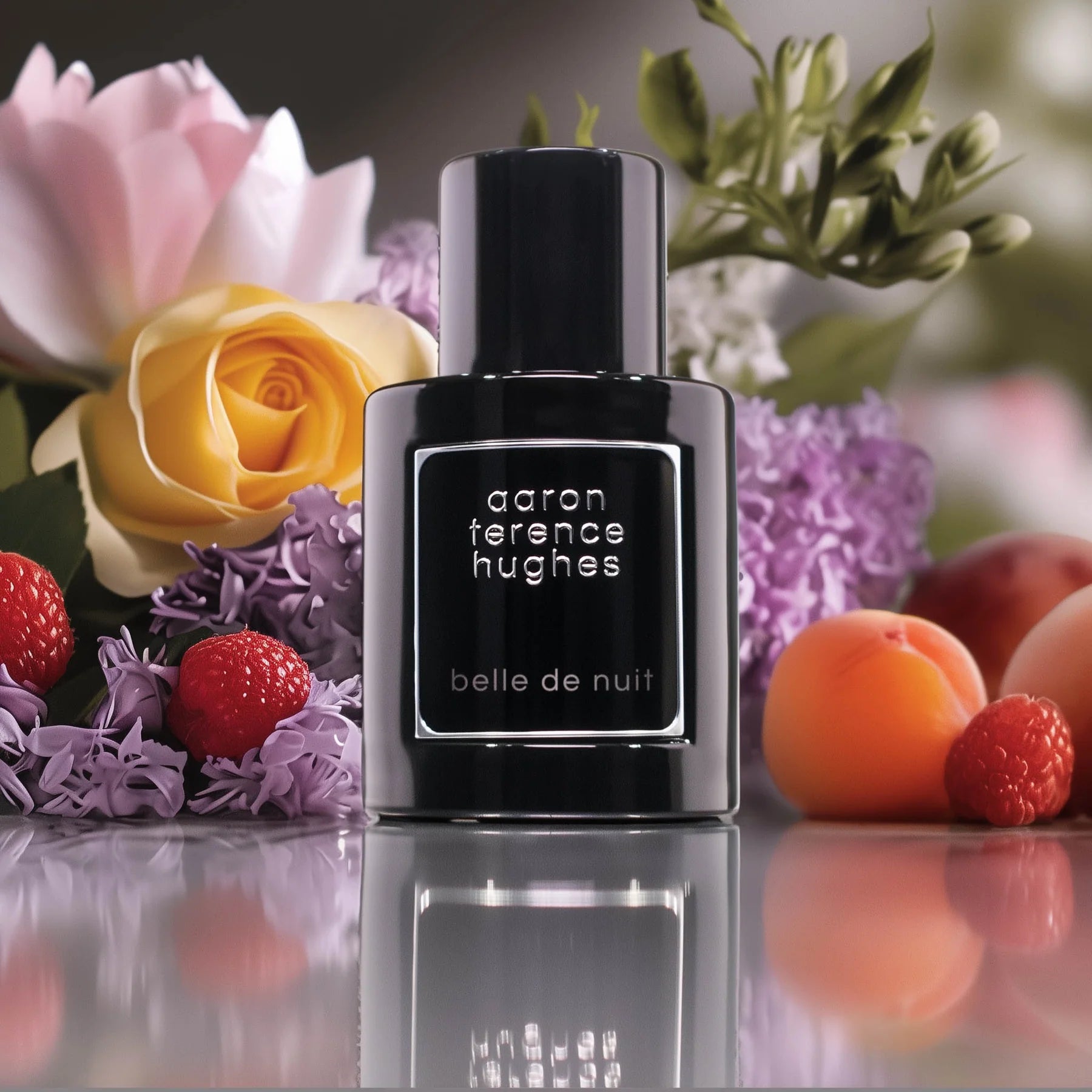 Flacon noir du parfum Belle De Nuit d'Aaron Terence Hughes entouré de fleurs et de fruits rouges.